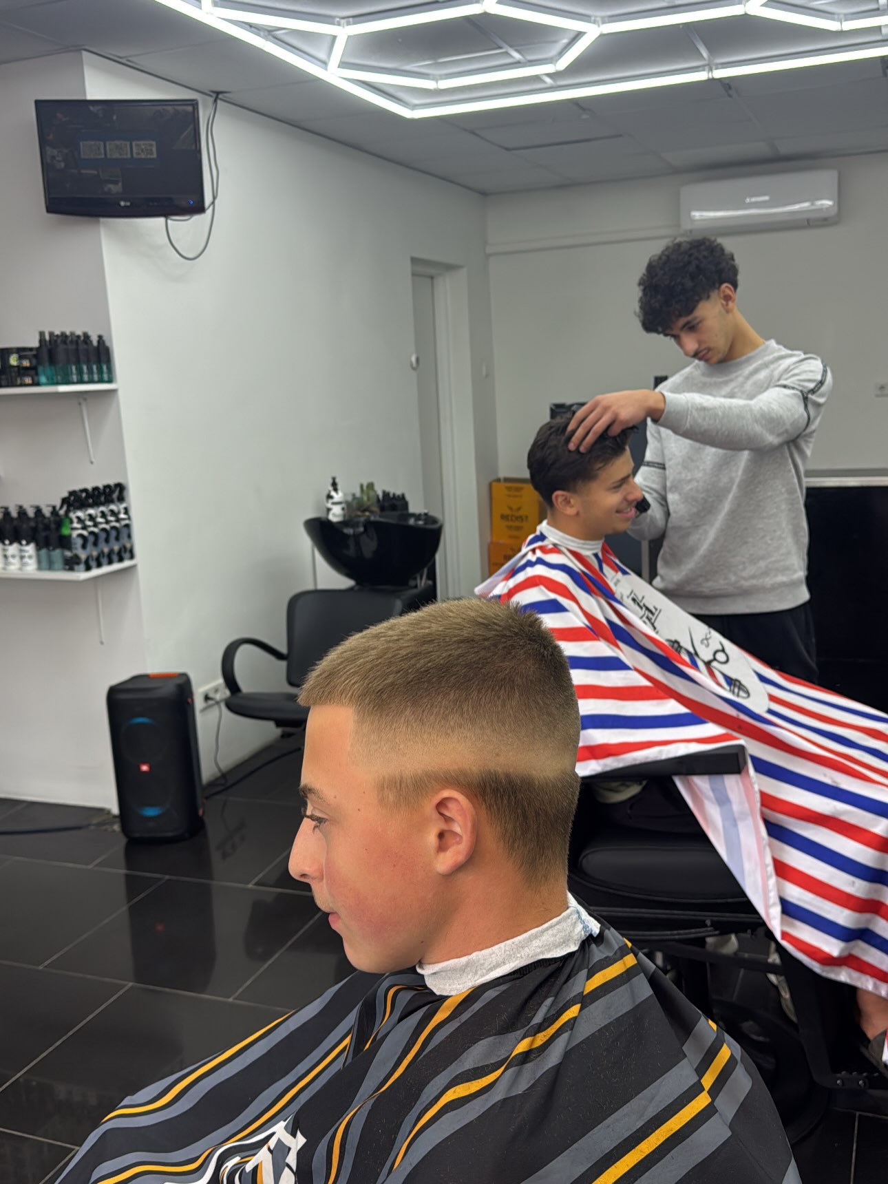 Skin fade, op de achtergrond knipt een collega
